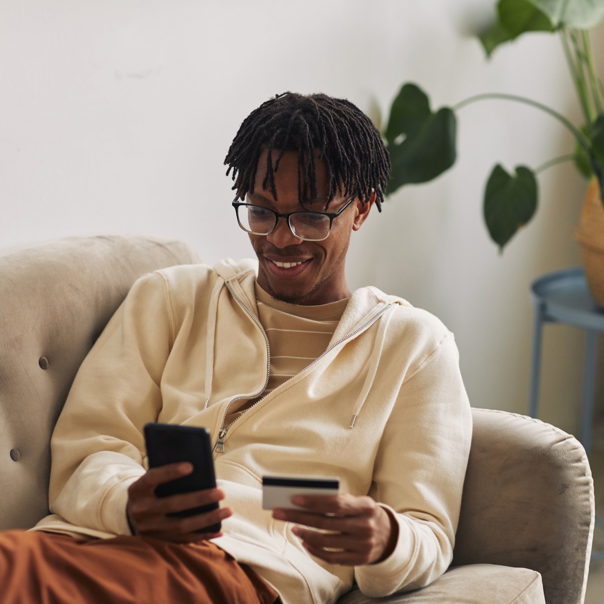 Cliente sorridente effettua l’ordine online del CleanOS Smartbrush con smartphone e carta di credito